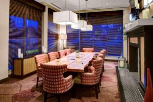 a dining room with a large wooden table and chairs at Hilton Garden Inn Atlanta North/Alpharetta in Alpharetta