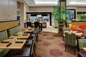 a restaurant with wooden tables and chairs and a bar at Hilton Garden Inn Atlanta North/Alpharetta in Alpharetta