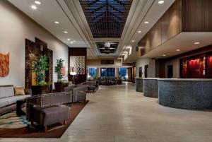 a lobby of a hotel with couches and a bar at Hilton Charlotte University Place in Charlotte