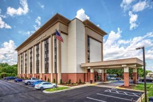 an exterior view of a hotel with cars parked in a parking lot at Hampton Inn Charlotte University Place in Charlotte