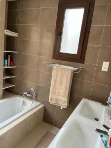 baño con lavabo, bañera y ventana en Luxury Salalah Villa, en Salalah
