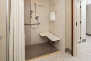 a bathroom with a shower with a bench in it at Hilton Bellevue in Bellevue