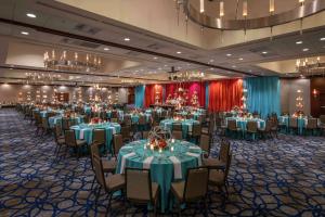 a banquet hall with tables and chairs and chandeliers at Hilton Bellevue in Bellevue