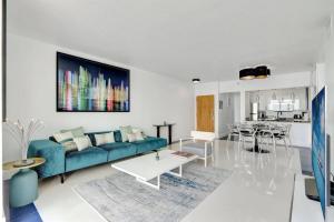 un salon avec un canapé bleu et une table dans l'établissement 3BR Penthouse with European Flair n Amazing Views, à Miami