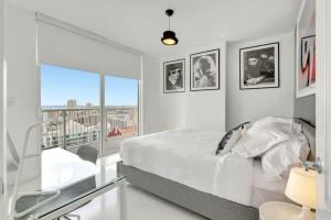 une chambre blanche avec un lit et un balcon dans l'établissement 3BR Penthouse with European Flair n Amazing Views, à Miami 26 autres photos