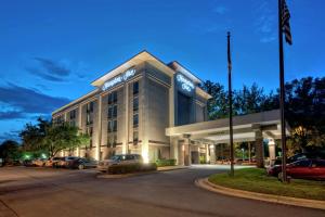 a hotel with cars parked in a parking lot at Hampton Inn Raleigh Cary in Cary