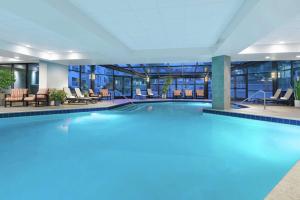 uma grande piscina num hotel com cadeiras e mesas em DoubleTree by Hilton Colorado Springs em Colorado Springs