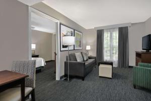 a hotel room with a couch and a bed at Homewood Suites by Hilton Houston-Clear Lake in Webster