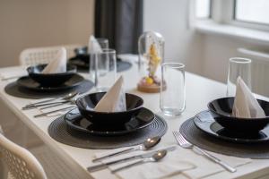 a table with black dishes and silverware on it at Isimi Burnley 3 bedroom modern house free parking in Burnley