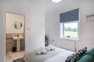 a bedroom with a bed and a sink and a window at Isimi Burnley 3 bedroom modern house free parking in Burnley