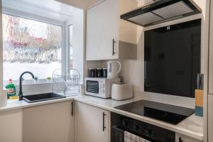 a kitchen with a sink and a microwave at Isimi Burnley 3 bedroom modern house free parking in Burnley