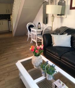 ein Wohnzimmer mit einem schwarzen Sofa und einem Tisch in der Unterkunft Dinky cottage in Brightlingsea