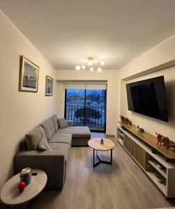 uma sala de estar com um sofá e uma televisão de ecrã plano em Departamento de Estreno en Barranco em Lima