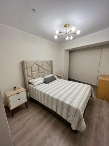 um quarto com uma cama grande e uma mesa de cabeceira em Departamento de Estreno en Barranco em Lima