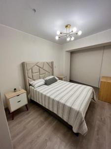 a bedroom with a large bed and a night stand at Departamento de Estreno en Barranco in Lima