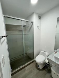 uma casa de banho com uma cabina de duche em vidro e um WC. em Departamento de Estreno en Barranco em Lima