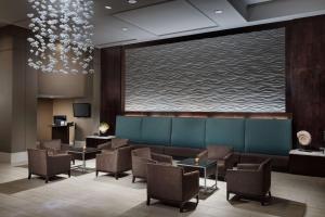 Embassy Suites by Hilton Orlando Lake Buena Vista Resort في أورلاندو: غرفة انتظار مع كراسي وشاشة كبيرة
