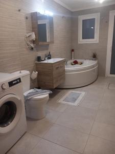 a bathroom with a tub and a toilet and a sink at Anemomylos House in Kámpos