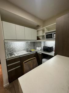 a kitchen with white cabinets and a counter top at 2 ambientes moderno y muy bien ubicado in Buenos Aires