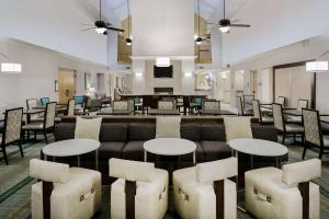 a lobby with a couch and tables and chairs at Homewood Suites Phoenix-Metro Center in Phoenix