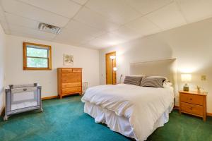 a bedroom with a large white bed and a dresser at Queensbury Lakefront Home Screened Porch and Views! in Queensbury
