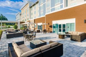 a patio with couches and tables and a building at Hilton Garden Inn Apopka City Center, Fl in Orlando