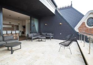 a patio with couches and tables and a staircase at ZOYA LUXURY RESIDENCE in Budapest
