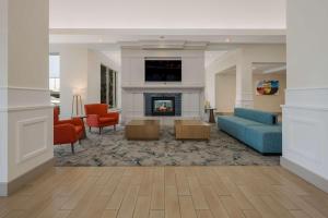 a living room with a couch and a fireplace at Hilton Garden Inn Rockford in Rockford