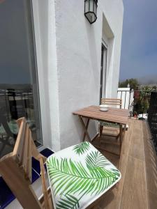 balkon ze stołem, krzesłem i ławką w obiekcie Duplex Triana III w mieście Bolonia
