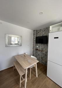 a kitchen with a wooden table and a refrigerator at Duplex Triana III in Bolonia