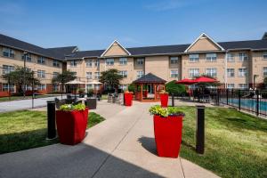 a building with four red containers with flowers in it at Residence Inn Cincinnati Airport in Erlanger