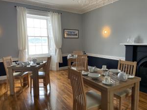 a dining room with two tables and chairs and a window at The Old Rectory in Inveraray