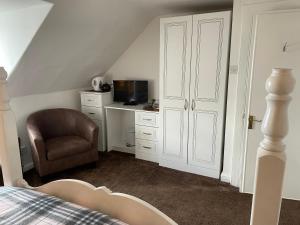 a bedroom with a bed and a chair and a microwave at The Old Rectory in Inveraray