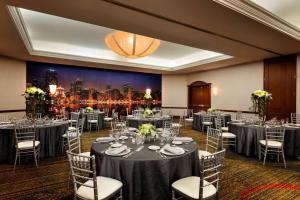 uma sala de banquetes com mesas e cadeiras e uma pintura de uma cidade em Hilton Chicago Magnificent Mile Suites em Chicago