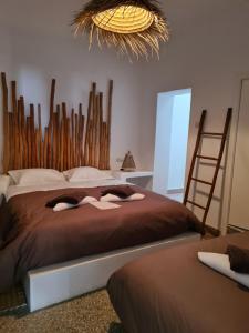 - une chambre avec un grand lit et une tête de lit en bois dans l'établissement La Maison des Vagues, à Sidi Kaouki