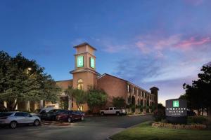 a large brick building with a clock tower on it at Embassy Suites Lubbock in Lubbock