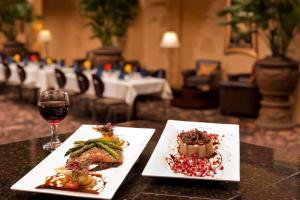 a table with two plates of food and a glass of wine at Embassy Suites Lubbock in Lubbock