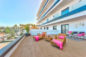 a balcony with chairs and tables on a building at Yuli in Puerto de la Cruz