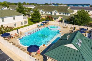 an overhead view of a swimming pool with chairs and umbrellas at The Tides --- 19979 Sandy Bottom Cir, Unit #502 in Rehoboth Beach