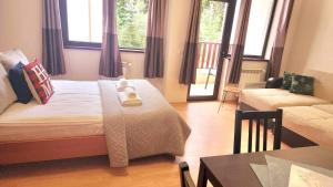 a bedroom with a bed and a couch and a table at Arboro Flora Residence Studio in Borovets +51 photos
