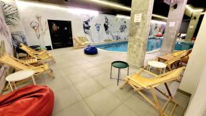 a room with chairs and a swimming pool at Arboro Flora Residence Studio in Borovets