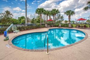 a swimming pool at a resort with palm trees at Hampton Inn & Suites Stuart-North in Stuart