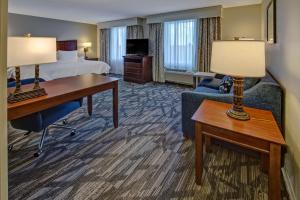 una camera d'albergo con letto, scrivania e divano di Hampton Inn & Suites Stuart-North a Stuart
