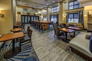 a waiting room with tables and chairs and windows at Hampton Inn & Suites Stuart-North in Stuart