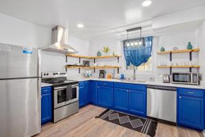 cocina con armarios azules y nevera de acero inoxidable en Lorna Leisure House - A, en Nashville