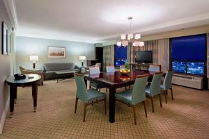 a living room with a dining room table and chairs at Hilton Springfield in Springfield