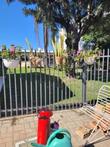uma cerca com vasos de plantas e um hidrante em Suíte com sala de estar em Lages