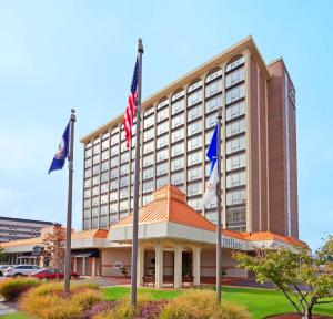um edifício de hotel com bandeiras em frente em Hilton Springfield em Springfield