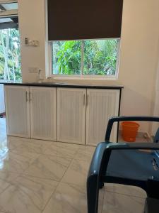 a kitchen with white cabinets and a window at Mango Tree Budget Home Stay in Homagama