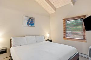 a bedroom with a large white bed and a window at Yampa View 307 in Steamboat Springs